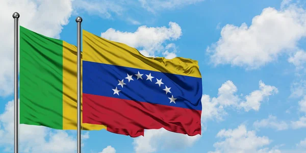 Mali i Wenezuela Flaga Macha w wiatr przed białym zachmurzone błękitne niebo razem. Koncepcja dyplomacji, stosunki międzynarodowe. — Zdjęcie stockowe