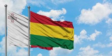 Malta ve Bolivya bayrağı birlikte beyaz bulutlu mavi gökyüzüne karşı rüzgarda sallayarak. Diplomasi kavramı, uluslararası ilişkiler.