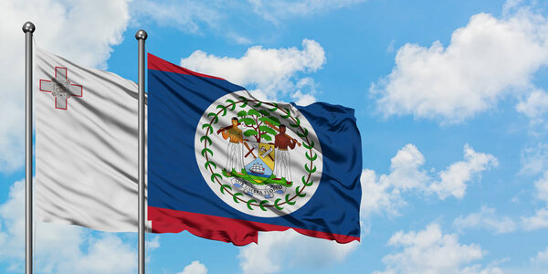 Мальта и Белиз вместе машут флагом на ветру против белого облачно-синего неба. Концепция дипломатии, международные отношения
.