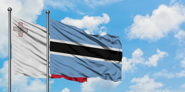 Malta and Botswana flag waving in the wind against white cloudy blue sky together. Diplomacy concept, international relations. — Stock Photo, Image