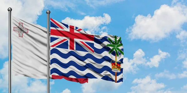 Malta and British Indian Ocean Territory flag waving in the wind against white cloudy blue sky together. Diplomacy concept, international relations. — Stock Photo, Image