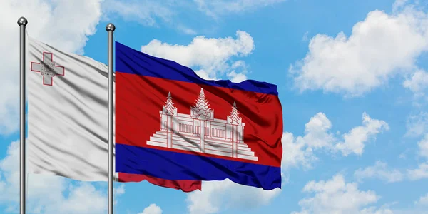 Malta og Kambodsjas flagg vinker i vinden mot den hvite blå himmelen sammen. Diplomatiskonsept, internasjonale forbindelser . – stockfoto