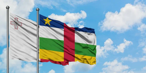 Bandera de Malta y República Centroafricana ondeando en el viento contra el cielo azul nublado blanco juntos. Concepto diplomático, relaciones internacionales . — Foto de Stock