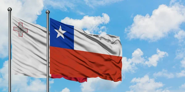 一緒に白い曇り青い空に対して風に手を振るマルタとチリの旗。外交概念、国際関係. — ストック写真
