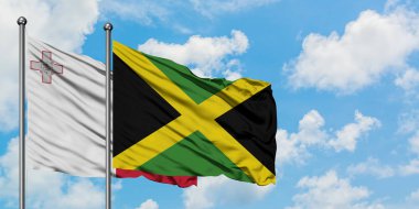 Malta ve Jamaika bayrağı birlikte beyaz bulutlu mavi gökyüzüne karşı rüzgarda sallayarak. Diplomasi kavramı, uluslararası ilişkiler.