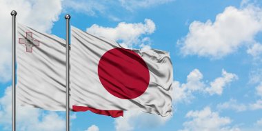 Malta ve Japonya bayrağı birlikte beyaz bulutlu mavi gökyüzüne karşı rüzgarda sallayarak. Diplomasi kavramı, uluslararası ilişkiler.