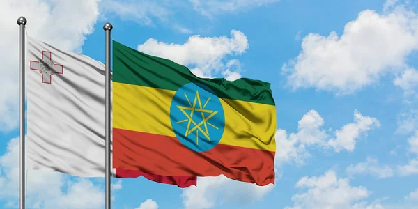 一緒に白い曇り青い空に対して風に振るマルタとエチオピアの旗。外交概念、国際関係. — ストック写真
