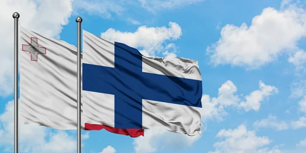 Bandera de Malta y Finlandia ondeando en el viento contra el cielo azul nublado blanco juntos. Concepto diplomático, relaciones internacionales . — Foto de Stock