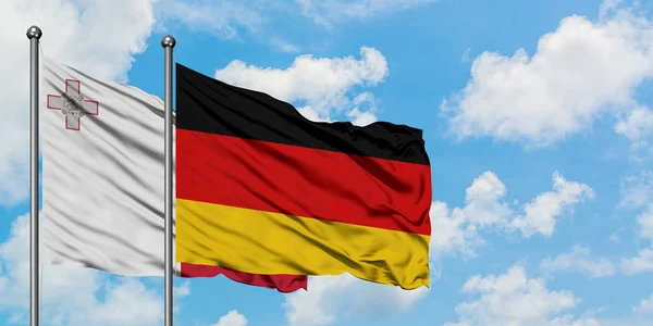 Málta és Németország zászló integetett a szél ellen, fehér felhős kék ég együtt. Diplomáciai koncepció, nemzetközi kapcsolatok. — Stock Fotó
