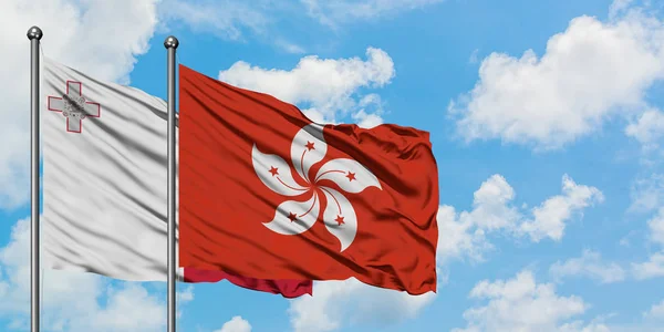 Bandera de Malta y Hong Kong ondeando en el viento contra el cielo azul nublado blanco juntos. Concepto diplomático, relaciones internacionales . —  Fotos de Stock