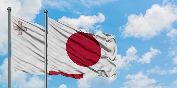 Malta dan Jepang mengibarkan bendera dalam angin melawan langit biru yang berawan putih bersama-sama. Konsep diplomasi, hubungan internasional . — Stok Foto