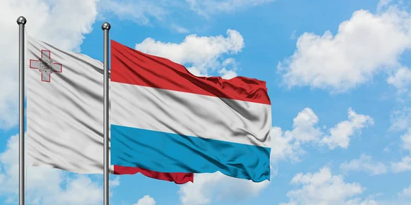 Malta i Luksemburg Flaga Macha w wiatr przed białym zachmurzone błękitne niebo razem. Koncepcja dyplomacji, stosunki międzynarodowe. — Zdjęcie stockowe