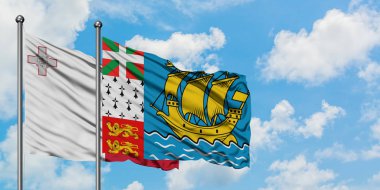 Malta ve Saint Pierre ve Miquelon bayrağı birlikte beyaz bulutlu mavi gökyüzüne karşı rüzgarda sallayarak. Diplomasi kavramı, uluslararası ilişkiler.