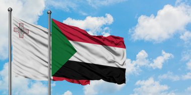 Malta ve Sudan bayrağı birlikte beyaz bulutlu mavi gökyüzüne karşı rüzgarsal sallayarak. Diplomasi kavramı, uluslararası ilişkiler.