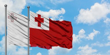 Malta ve Tonga bayrağı birlikte beyaz bulutlu mavi gökyüzüne karşı rüzgarda sallayarak. Diplomasi kavramı, uluslararası ilişkiler.