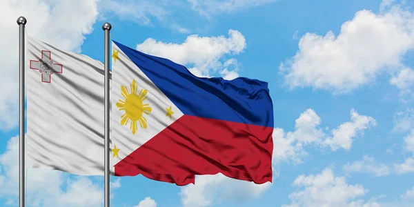 Bandera de Malta y Filipinas ondeando en el viento contra el cielo azul nublado blanco juntos. Concepto diplomático, relaciones internacionales . —  Fotos de Stock