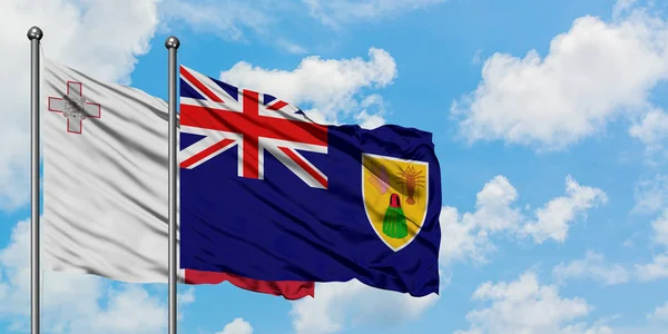 Bandera de Malta y las Islas Turcas y Caicos ondeando en el viento contra el cielo azul nublado blanco juntos. Concepto diplomático, relaciones internacionales . — Foto de Stock