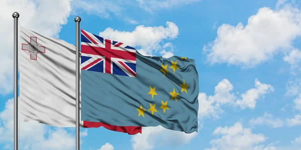 Bandera de Malta y Tuvalu ondeando en el viento contra el cielo azul nublado blanco juntos. Concepto diplomático, relaciones internacionales . — Foto de Stock