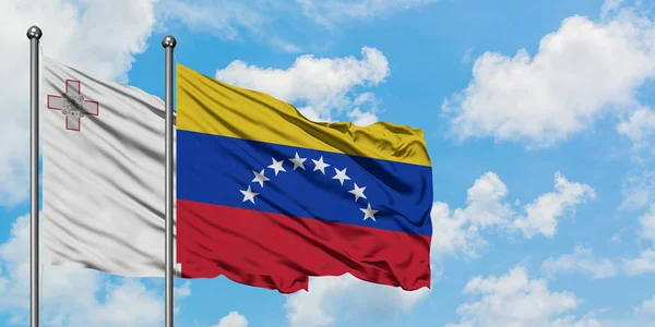 Malta and Venezuela flag waving in the wind against white cloudy blue sky together. Diplomacy concept, international relations. — Stock Photo, Image