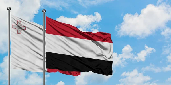 Malta e o Iémen acenam ao vento contra o céu azul nublado branco juntos. Conceito de diplomacia, relações internacionais . — Fotografia de Stock