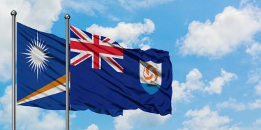 Marshall Adaları ve Anguilla bayrağı birlikte beyaz bulutlu mavi gökyüzüne karşı rüzgarda sallayarak. Diplomasi kavramı, uluslararası ilişkiler.