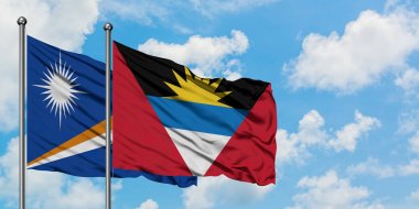 Marshall Adaları ve Antigua ve Barbuda bayrağı birlikte beyaz bulutlu mavi gökyüzüne karşı rüzgarda sallayarak. Diplomasi kavramı, uluslararası ilişkiler.
