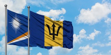 Marshall Adaları ve Barbados bayrağı birlikte beyaz bulutlu mavi gökyüzüne karşı rüzgarda sallayarak. Diplomasi kavramı, uluslararası ilişkiler.