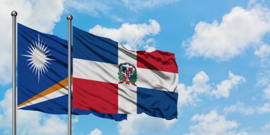 Marshall Adaları ve Dominik Cumhuriyeti bayrağı birlikte beyaz bulutlu mavi gökyüzüne karşı rüzgarda sallayarak. Diplomasi kavramı, uluslararası ilişkiler.