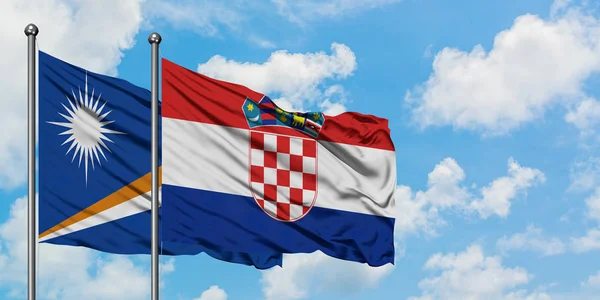 Bandera de las Islas Marshall y Croacia ondeando en el viento contra el cielo azul nublado blanco juntos. Concepto diplomático, relaciones internacionales . — Foto de Stock