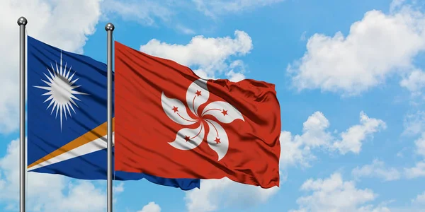 Marshall Adaları ve Hong Kong bayrağı birlikte beyaz bulutlu mavi gökyüzüne karşı rüzgarda sallayarak. Diplomasi kavramı, uluslararası ilişkiler. — Stok fotoğraf