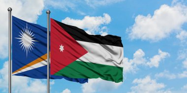 Marshall Adaları ve Ürdün bayrağı birlikte beyaz bulutlu mavi gökyüzüne karşı rüzgarda sallayarak. Diplomasi kavramı, uluslararası ilişkiler.