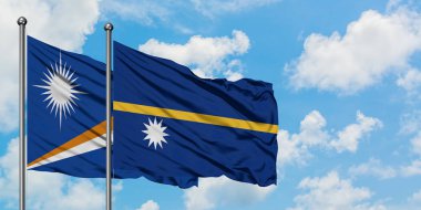 Marshall Adaları ve Nauru bayrağı birlikte beyaz bulutlu mavi gökyüzüne karşı rüzgarda sallayarak. Diplomasi kavramı, uluslararası ilişkiler.