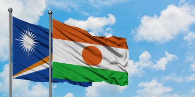 Marshall Adaları ve Nijer bayrağı birlikte beyaz bulutlu mavi gökyüzüne karşı rüzgarda sallayarak. Diplomasi kavramı, uluslararası ilişkiler.