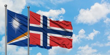 Marshall Adaları ve Norveç bayrağı birlikte beyaz bulutlu mavi gökyüzüne karşı rüzgarda sallayarak. Diplomasi kavramı, uluslararası ilişkiler.