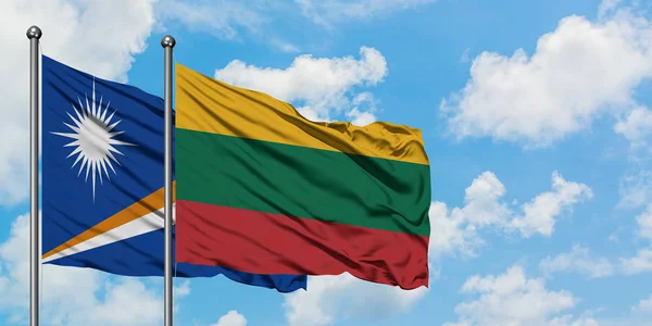 Bandera de las Islas Marshall y Lituania ondeando en el viento contra el cielo azul nublado blanco juntos. Concepto diplomático, relaciones internacionales . — Foto de Stock