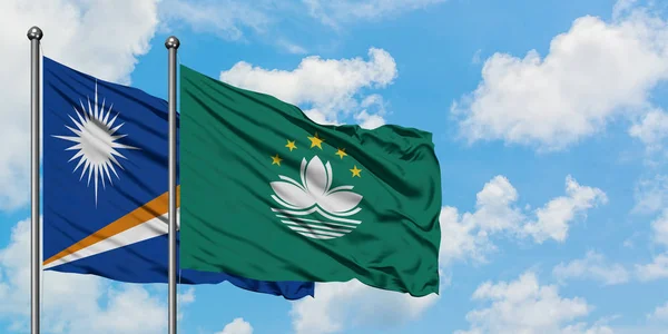 Marshall Islands and Macao flag waving in the wind against white cloudy blue sky together. Diplomacy concept, international relations.