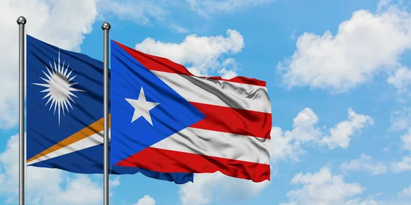 Marshall Adaları ve Porto Riko bayrağı birlikte beyaz bulutlu mavi gökyüzüne karşı rüzgarda sallayarak. Diplomasi kavramı, uluslararası ilişkiler. — Stok fotoğraf