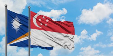 Marshall Adaları ve Singapur bayrağı birlikte beyaz bulutlu mavi gökyüzüne karşı rüzgarda sallayarak. Diplomasi kavramı, uluslararası ilişkiler.