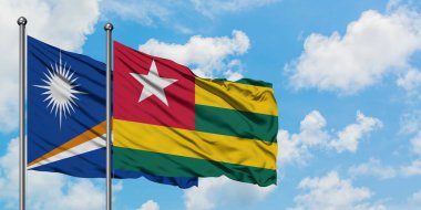 Marshall Adaları ve Togo bayrağı birlikte beyaz bulutlu mavi gökyüzüne karşı rüzgarda sallayarak. Diplomasi kavramı, uluslararası ilişkiler.