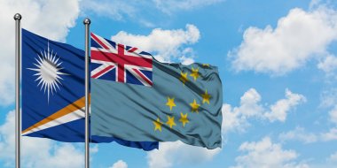 Marshall Adaları ve Tuvalu bayrağı birlikte beyaz bulutlu mavi gökyüzüne karşı rüzgarda sallayarak. Diplomasi kavramı, uluslararası ilişkiler.