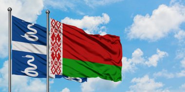 Martinik ve Beyaz Rusya bayrağı birlikte beyaz bulutlu mavi gökyüzüne karşı rüzgarda sallayarak. Diplomasi kavramı, uluslararası ilişkiler.