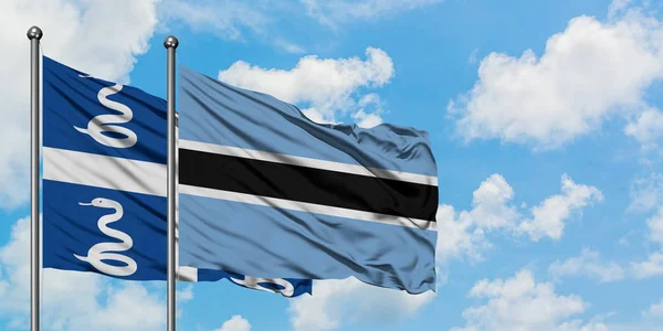 Martinica e Botswana sventolano nel vento contro il bianco cielo azzurro nuvoloso insieme. Concetto di diplomazia, relazioni internazionali . — Foto Stock