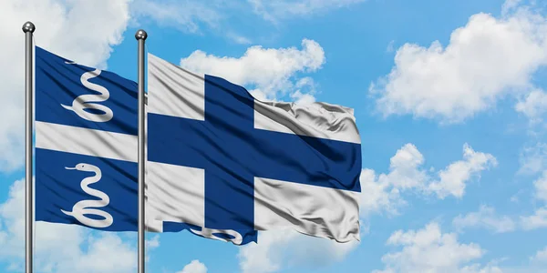 Bandera de Martinica y Finlandia ondeando en el viento contra el cielo azul nublado blanco juntos. Concepto diplomático, relaciones internacionales . — Foto de Stock