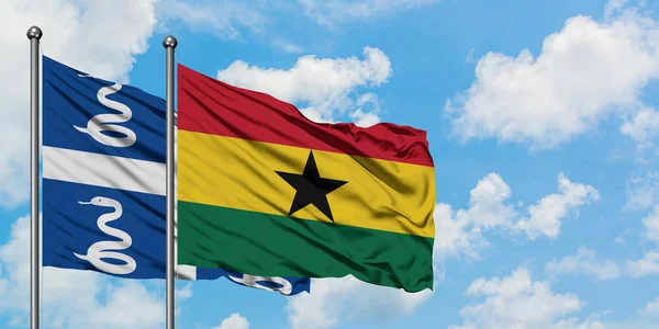 Bandera de Martinica y Ghana ondeando en el viento contra el cielo azul nublado blanco juntos. Concepto diplomático, relaciones internacionales . — Foto de Stock