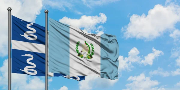 Bandera de Martinica y Guatemala ondeando en el viento contra el cielo azul nublado blanco juntos. Concepto diplomático, relaciones internacionales . — Foto de Stock