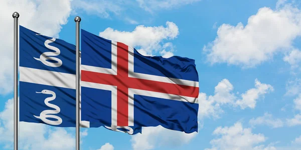 Martinica y la bandera de Islandia ondeando en el viento contra el cielo azul nublado blanco juntos. Concepto diplomático, relaciones internacionales . — Foto de Stock