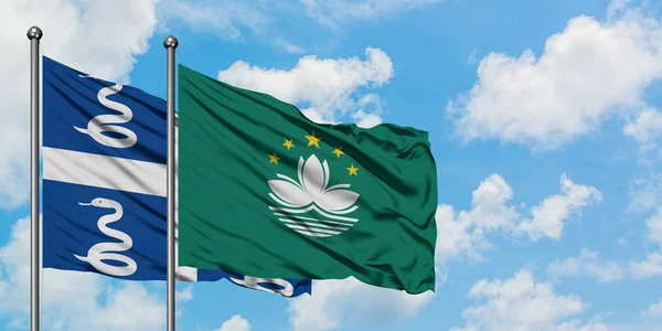 Martinique and Macao flag waving in the wind against white cloudy blue sky together. Diplomacy concept, international relations.