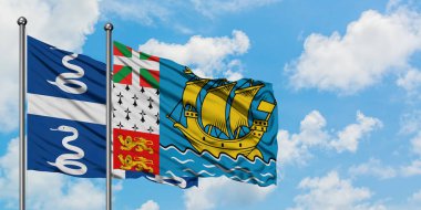 Martinik ve Saint Pierre ve Miquelon bayrağı birlikte beyaz bulutlu mavi gökyüzüne karşı rüzgarda sallayarak. Diplomasi kavramı, uluslararası ilişkiler.