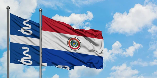 Bandera de Martinica y Paraguay ondeando en el viento contra el cielo azul nublado blanco juntos. Concepto diplomático, relaciones internacionales . —  Fotos de Stock