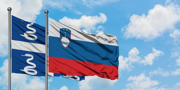 Martinique and Slovenia flag waving in the wind against white cloudy blue sky together. Diplomacy concept, international relations. — Stock Photo, Image